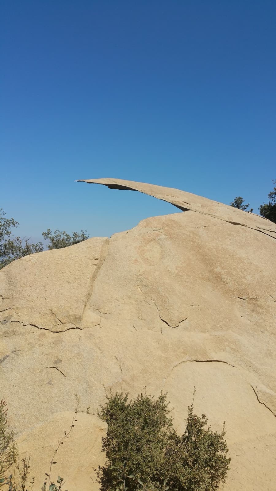 Potato Chip Rock, a thin slab of granite jutting out from a boulder against a deep blue sky.